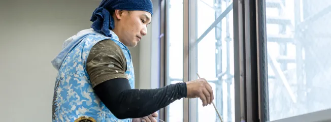 名古屋市で外壁塗装の仕上げ作業を行う職人が細部まで丁寧に施工している様子