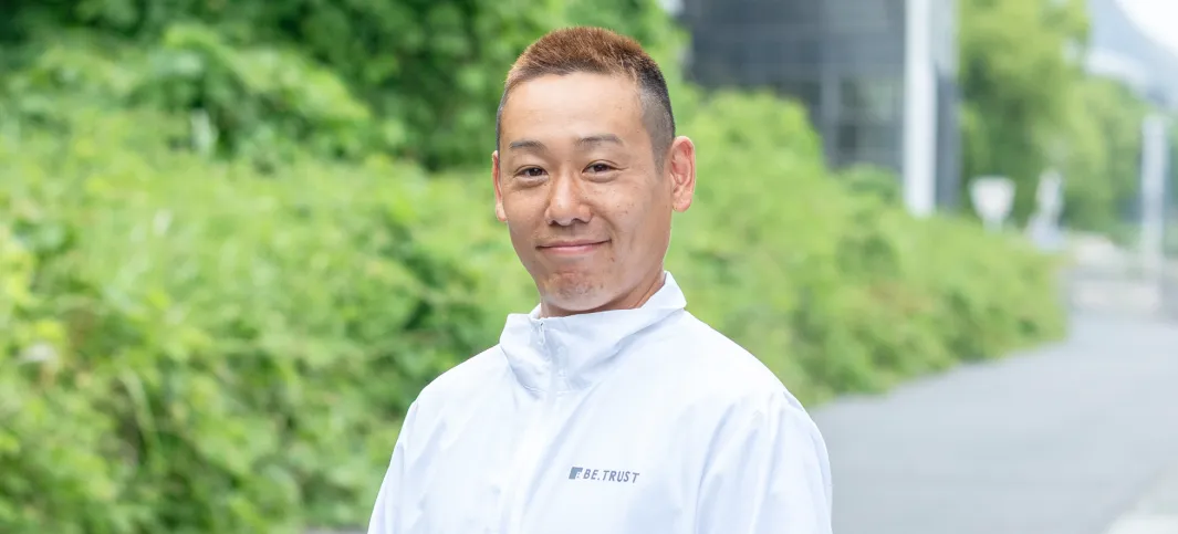 ビートラストの職人（塗装）桑岡良太の笑顔のポートレート写真。